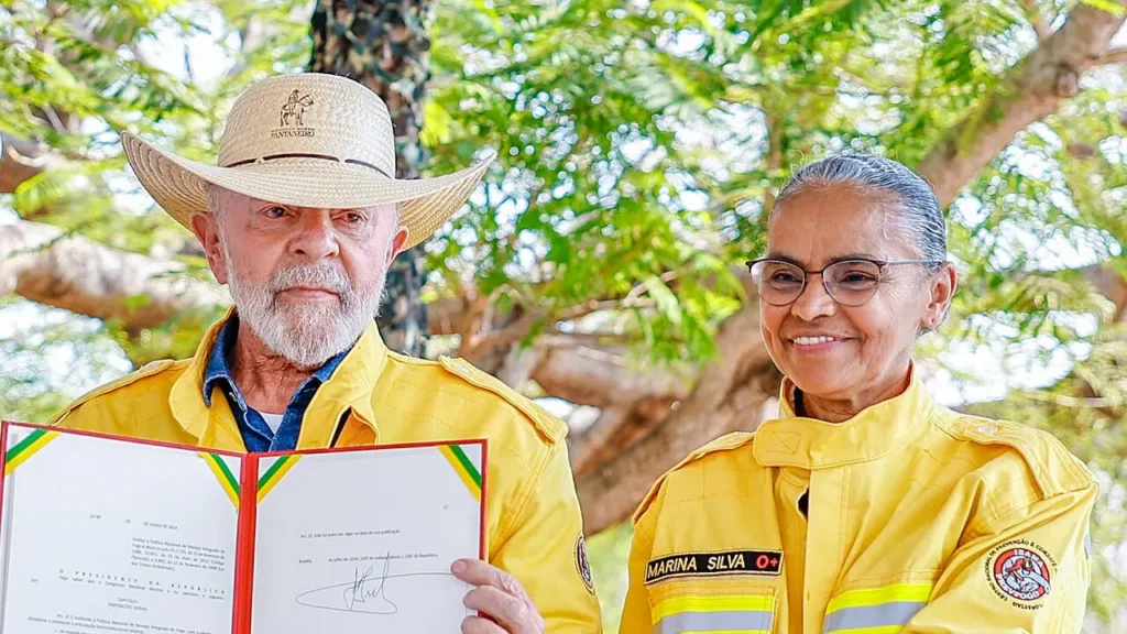 Presidente Lula de chapéu e jaqueta de brigadista ao lado de Marina Silva