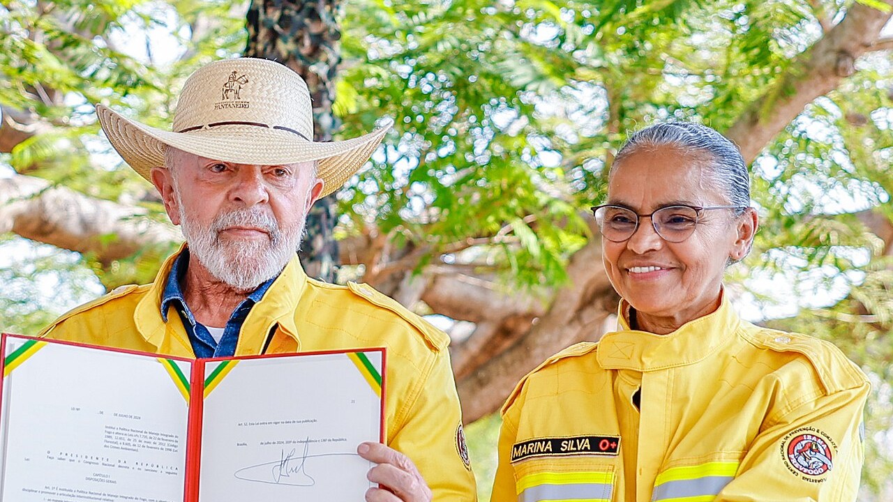 Presidente Lula de chapéu e jaqueta de brigadista ao lado de Marina Silva